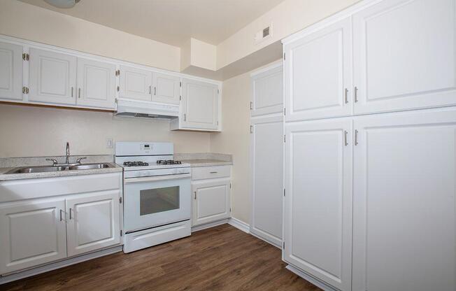 a kitchen with white appliances and wooden cabinets