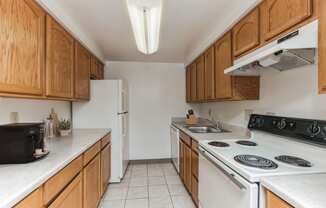 a kitchen with white appliances and wooden cabinets