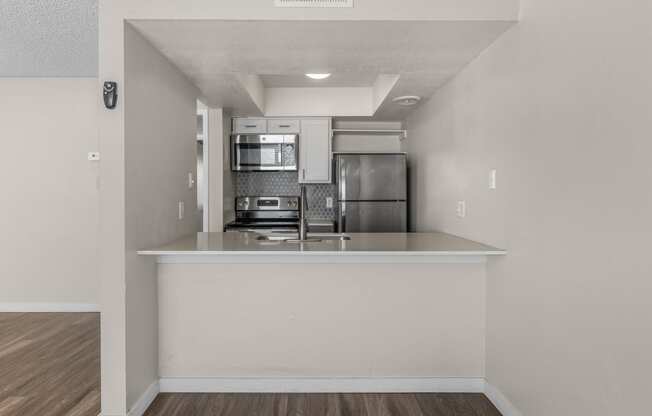 an empty kitchen with a counter top and a refrigerator and