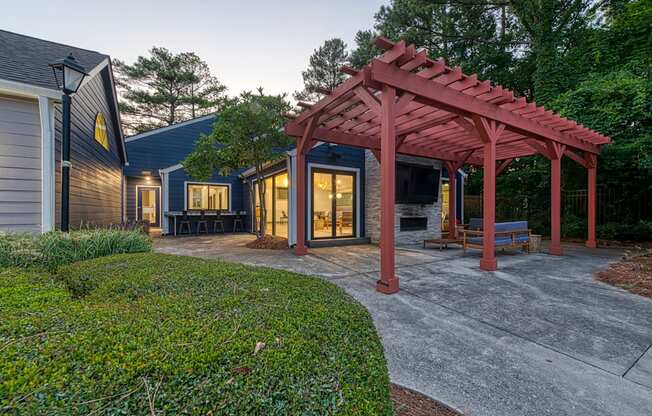 A house with a red pergola and a grey driveway.