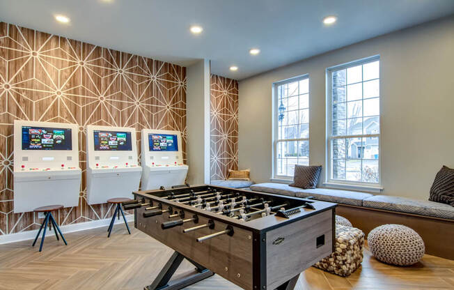 a games room with a foosball table and three arcade games