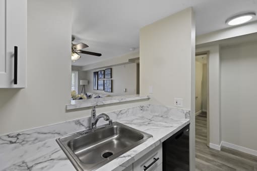 a kitchen with a sink and a mirror  at Camelot Apartment Homes, Everett, WA, 98204