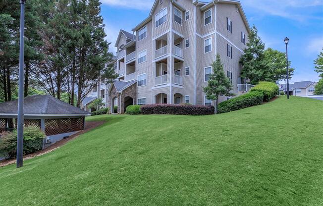 A large apartment building with a green lawn in front.