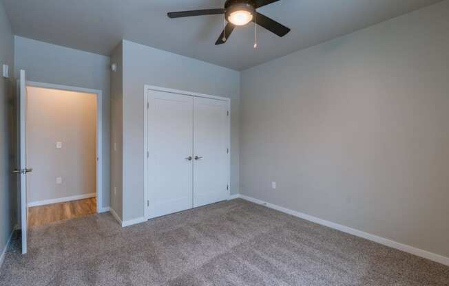a bedroom with a ceiling fan and a closet. Fargo, ND Prairiewood Meadows