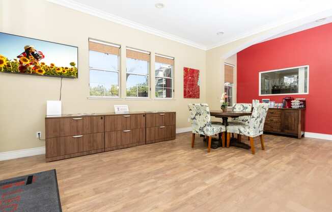 a dining room with red walls and a table and chairs