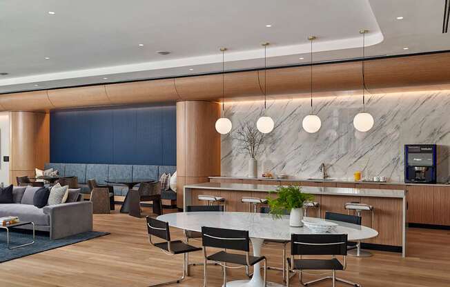 A modern dining area with a marble counter and black chairs.