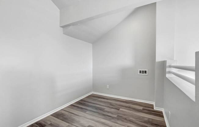 an empty room with white walls and a wooden floor