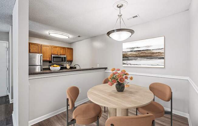 A kitchen with a table and chairs.