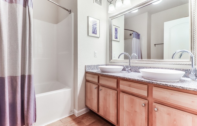 A bathroom with a white tub, wooden cabinets, and a large mirror, Plantation Crossing, Lafayette, LA, 70508