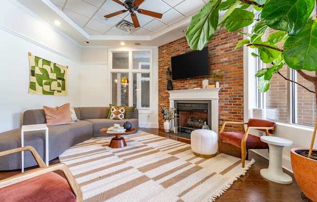 a living room with a brick fireplace and a rug