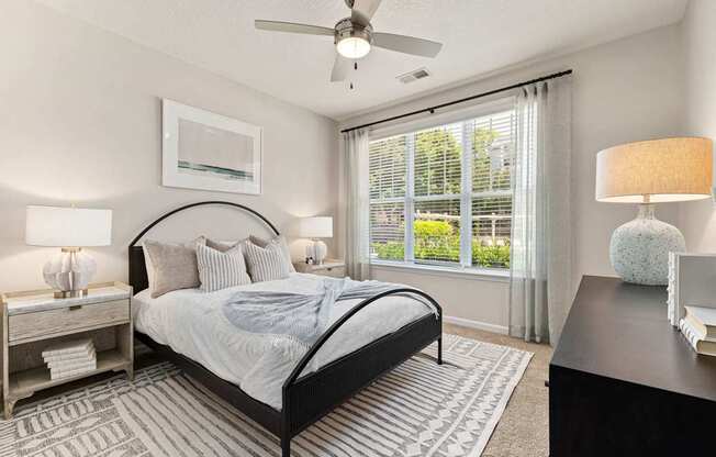 A bedroom with a large bed and a ceiling fan.