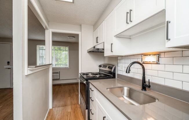 Renovated kitchen with granite countertops and white cabinetry