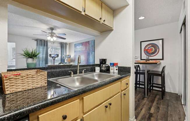 A kitchen with a black countertop and wooden cabinets.