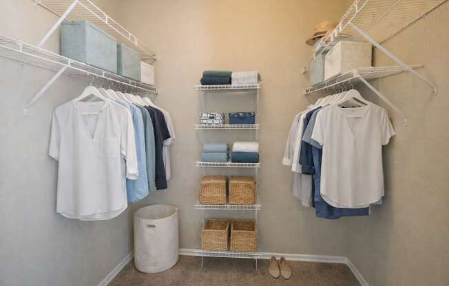 A white shirt is hanging on a rack in a closet.