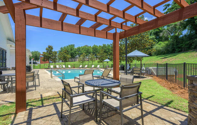 A patio with a table and chairs under a pergola.at Spring Creek Apartments, Florida, 32536