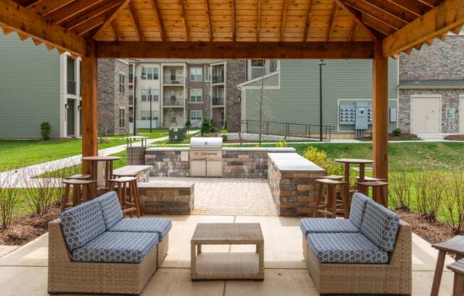 a covered patio with wicker furniture and a fire pit at The Whitworth, Williamsburg, Virginia