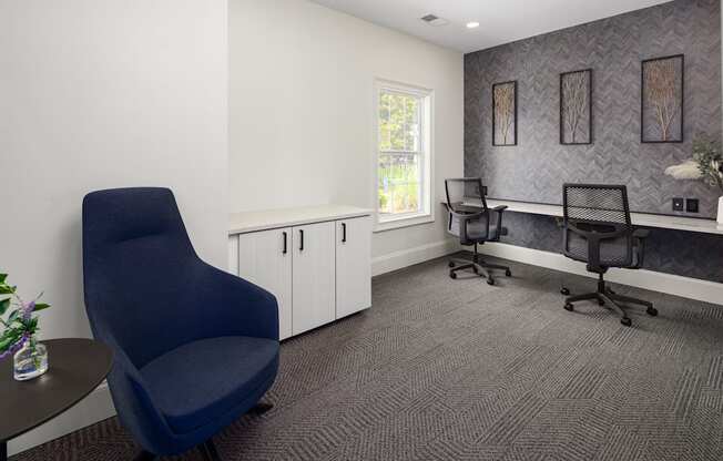 an office with two chairs and a desk and a window