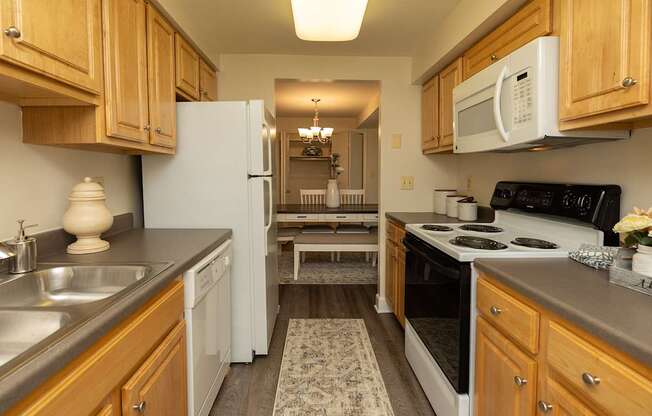A kitchen with wooden cabinets and a white refrigerator.