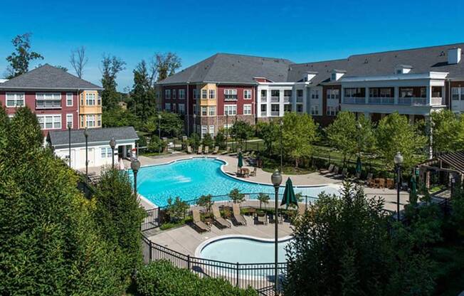 an aerial view of a swimming pool with apartments in the background