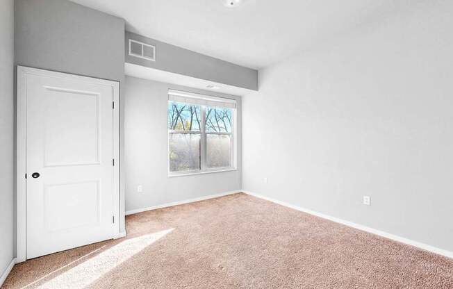 A room with a white door and carpeted floor.