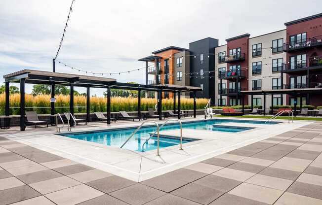 Outdoor pool at Ironwood complete with gazebos, lounge seating, and lights hanging above the deck.