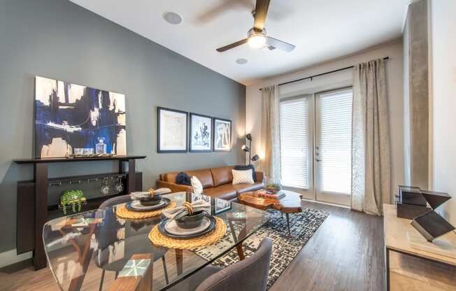 Interior of apartment living area facing exterior windows and a couch facing a television