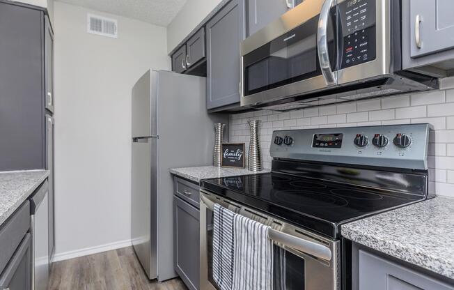 a stove top oven sitting inside of a kitchen with stainless steel appliances