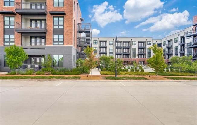 A large, empty parking lot in front of apartment buildings.