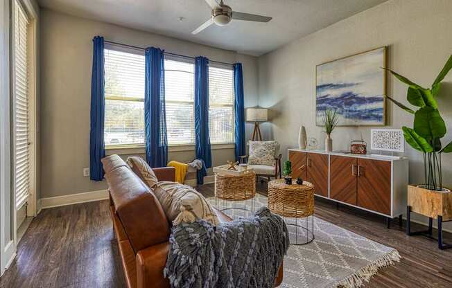 A living room with a brown leather sofa and a grey area rug.