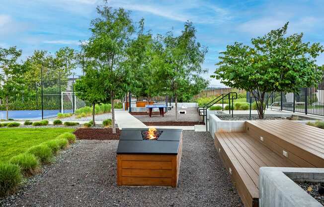 A backyard with a fire pit and picnic table.