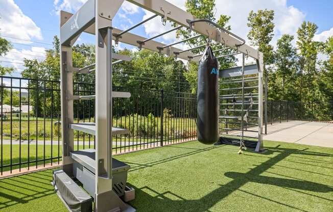 a punching bag in fenced in area with a wrought iron fence