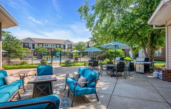 a patio with blue chairs and tables and umbrellas