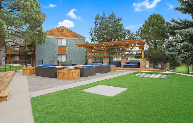 A large building with a wooden pergola and a green lawn in front at Mountain Vista Apartments, Lakewood, Colorado