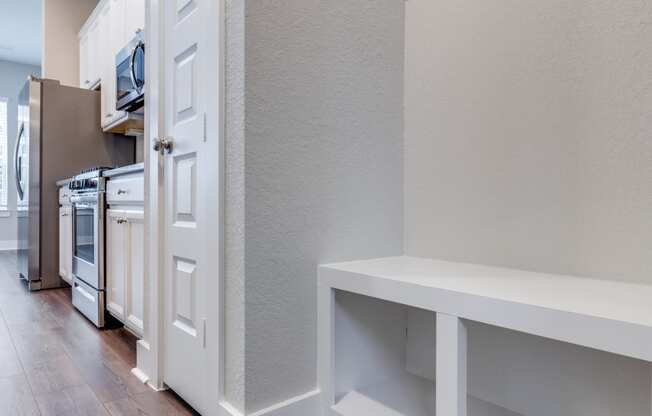 a renovated kitchen with white cabinets and a wood floor