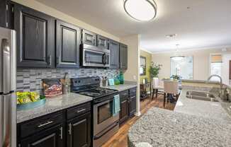 a kitchen with granite counter tops and black cabinets