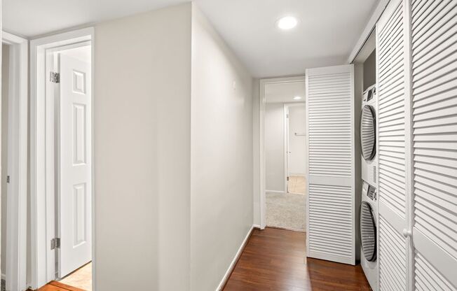 A hallway with a closet and washer and dryer.