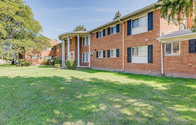 A red brick building with a green lawn in front.