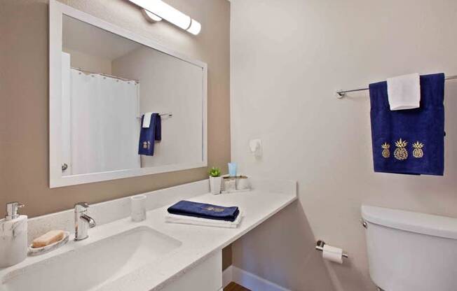 A bathroom with a white sink and a blue towel hanging on the wall.