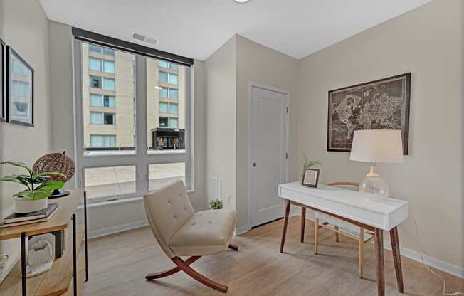 a bedroom with a desk and a chair and a window