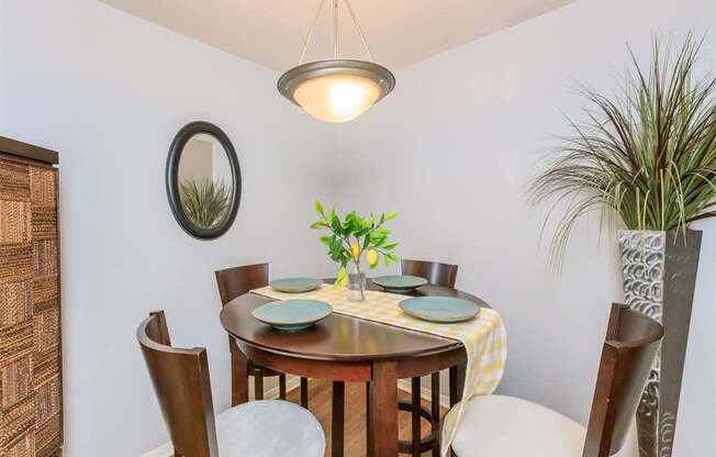 A dining room with a round table set for four.