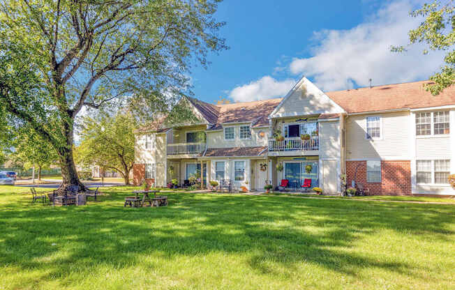 a large house with a lawn and a tree