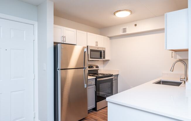 a renovated kitchen with stainless steel appliances and white cabinets