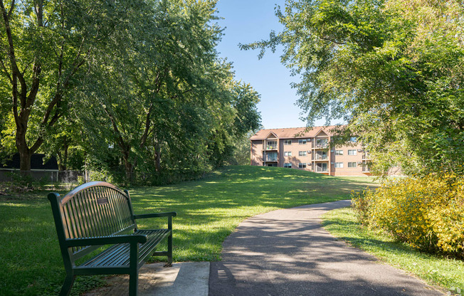 a park bench sitting next to a sidewalk