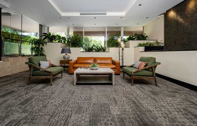 A living room with a grey carpet and a brown couch.