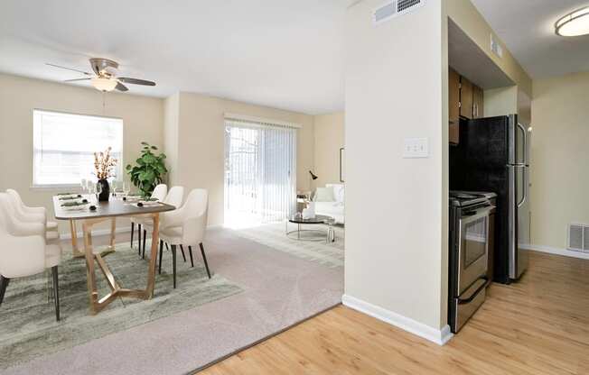 an open living room and dining room with a table and chairs at West Pointe Apartments in Burlington, NC