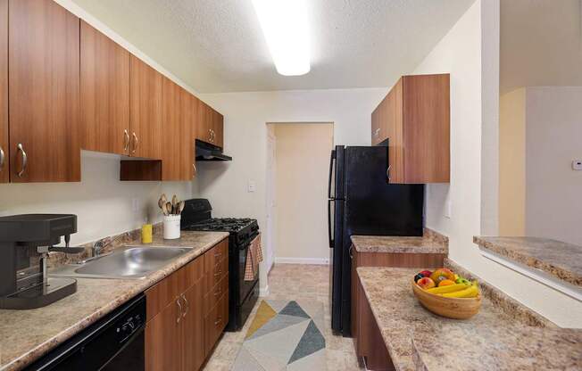 A kitchen with brown cabinets and black appliances.