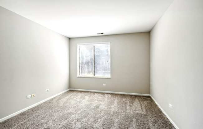 an empty room with carpet and a window