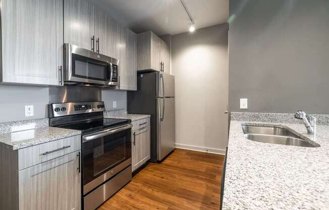 A kitchen with a stove, oven, microwave, and refrigerator.
