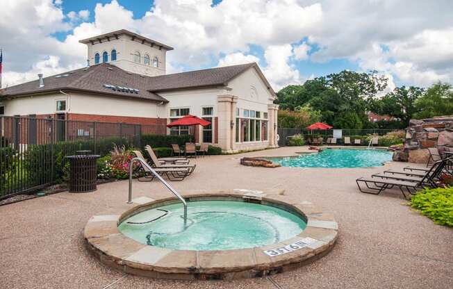a pool with a hot tub in front of a house
