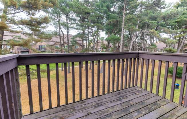 a deck with a view of a yard and trees